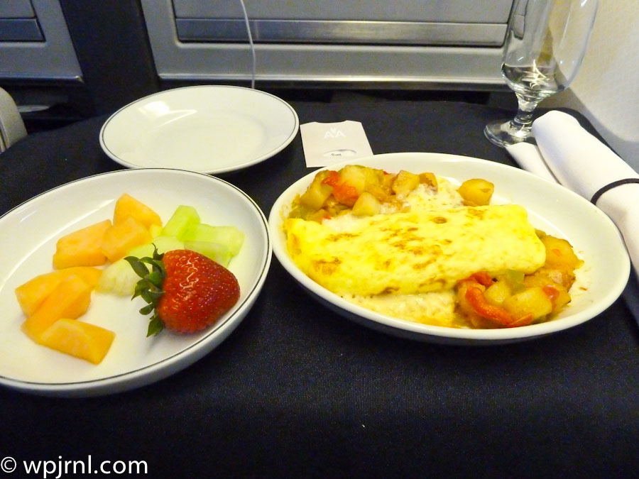 First Class Airline Breakfast with Omelet, Roasted Potatoes, and Fresh Fruit
